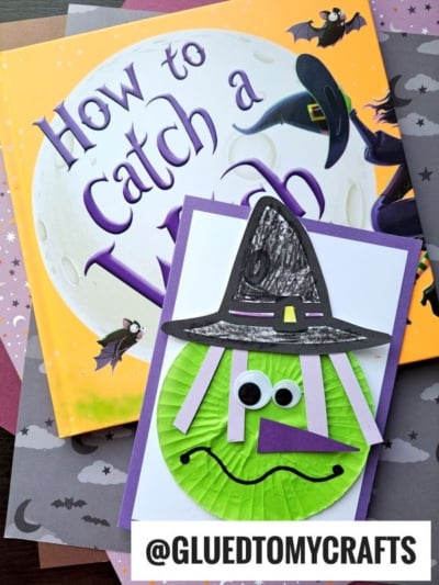 A children’s book titled How to Catch a Witch sits beside a handmade cupcake liner green witch card, featuring googly eyes, a green cupcake liner face, and a black paper hat. The username @GLUEDTOMYCRAFTS is at the bottom.
