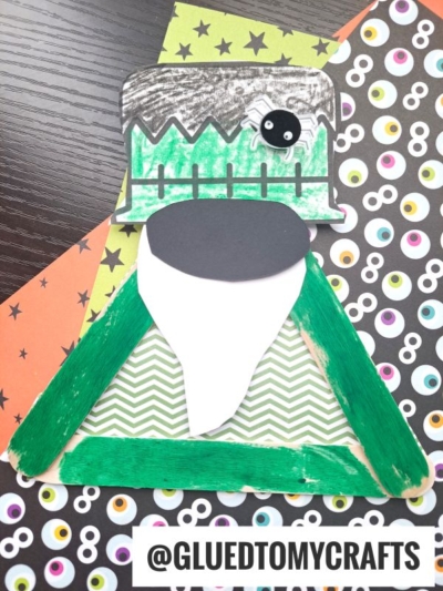 A Frankenstein gnome monster craft made with green popsicle sticks, patterned paper, a large eye, and crayon details, displayed on colorful Halloween-themed backgrounds. Text at the bottom reads @GLUEDTOMYCRAFTS.