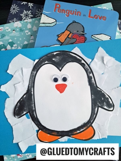 A Penguin On Ice Craft features a paper penguin with googly eyes glued to blue paper and torn white “snow,” set beside the book Penguin in Love and a snowflake-patterned sheet. The text @GLUEDTOMYCRAFTS appears at the bottom.