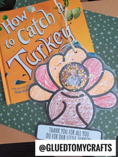 A children’s book titled How to Catch a Turkey sits on patterned paper beside a Turkey Photo Ornament craft, decorated with glitter and a child’s photo in the center. A tag reads, Thank you for all you do for our little turkey!.