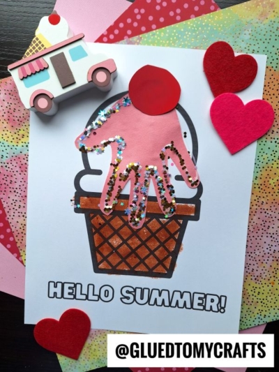 A handprint hello summer craft featuring an ice cream cone with a pink, sprinkle-covered scoop and red cherry, surrounded by felt hearts and a toy ice cream truck, captioned HELLO SUMMER! and @GLUEDTOMYCRAFTS.