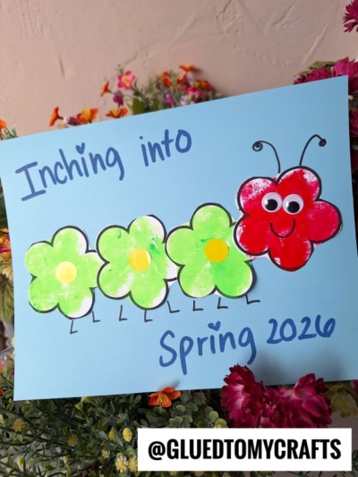 A blue card features a charming flower caterpillar made from green and red flower shapes, googly eyes, and drawn legs, with “Inching into Spring 2026.” Colorful flowers bloom in the background. @GLUEDTOMYCRAFTS is at the bottom.