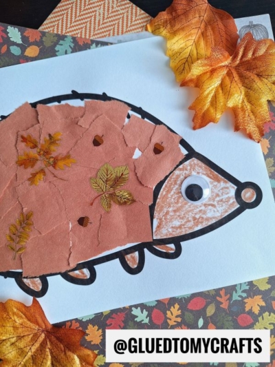 A torn paper hedgehog craft features a body made from ripped brown paper, a googly eye, and fake autumn leaves on white paper. The background pops with fall-themed paper and leaves. @GLUEDTOMYCRAFTS is displayed at the bottom.