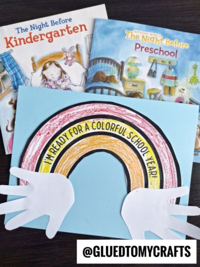 Two children’s books, The Night Before Kindergarten and The Night Before Preschool, sit behind a handmade Back To School Rainbow craft with white handprints and the message, “I’m ready for a colorful school year!”.