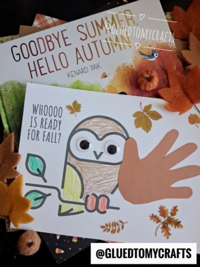 A fall-themed craft scene with a children’s book titled Goodbye Summer, Hello Autumn, a handprint owl drawing with googly eyes, and decorative felt leaves scattered around. Text reads Whoooo is ready for fall?.