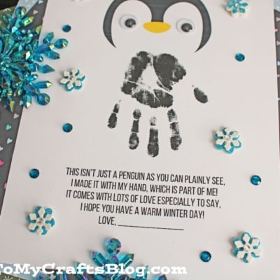 A handmade penguin card features a child’s black handprint as the penguin’s body, googly eyes, snowflake decorations, and a printed winter poem. Surround it with patterned paper for extra flair—perfect to pair with All Our Free Penguin Printables - Landing Page.