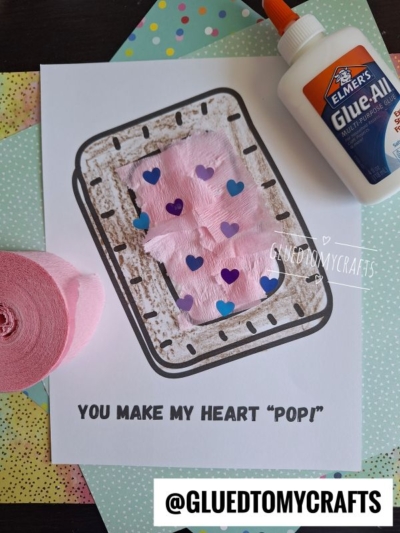 A handmade craft on paper reads YOU MAKE MY HEART POP! It features pink tissue, heart-shaped confetti, a torn paper pastry, a glue bottle, and pastel papers. The handle @GLUEDTOMYCRAFTS is at the bottom.