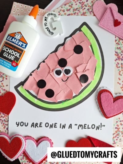 A torn paper watermelon craft with googly eyes and a smile on white paper, surrounded by felt hearts, a glue bottle, and the caption YOU ARE ONE IN A MELON! at the bottom.
