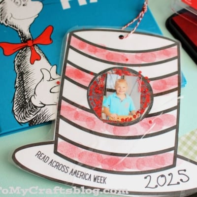 A handmade Dr. Seuss hat photo frame craft, perfect as a Cat in the Hat ornament, holds a child's picture on a table beside The Cat in the Hat book.