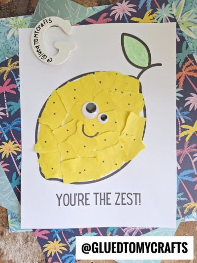 A fun craft project showcasing a torn paper lemon with googly eyes and a drawn smile on white paper. The text reads YOU’RE THE ZEST! with @GLUEDTOMYCRAFTS displayed at the bottom.