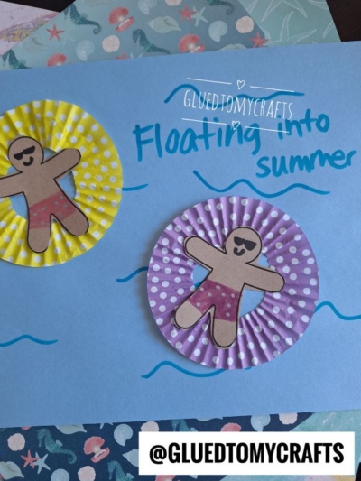 A craft project features two paper gingerbread people on cupcake liner pool floaties, with blue waves and the caption Floating into summer handwritten on blue paper.