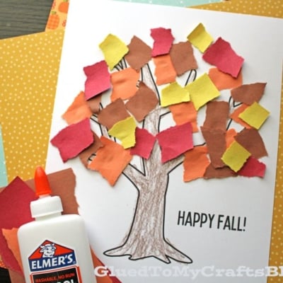 A torn paper tree craft with a printed tree outline, colorful torn paper leaves, Elmer’s glue, and text that says HAPPY FALL! set against an autumn-themed paper background.