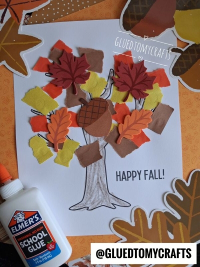 A fall craft shows a torn paper tree with colorful fabric and paper leaves, an acorn, school glue, autumn decorations, and the words HAPPY FALL! and @GLUEDTOMYCRAFTS on a white background.