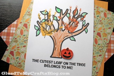 A children’s craft project featuring a printable tree with colorful handprint leaves and a small orange pumpkin cutout. This cutest leaf keepsake reads: THE CUTEST LEAF ON THE TREE BELONGS TO ME!