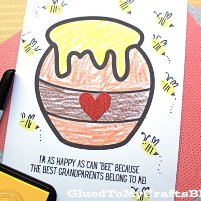 A printable coloring page featuring a honey pot with a glittery red heart, dripping honey, and surrounded by cute thumbprint bees. Text reads: I'M AS HAPPY AS CAN BEE BECAUSE THE BEST GRANDPARENTS BELONG TO ME!.