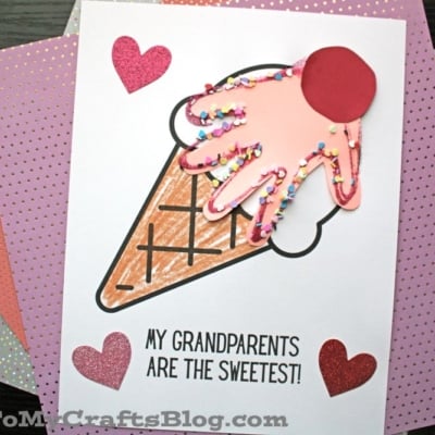 A handmade grandparent's day ice cream keepsake card featuring a paper cone, pink handprint ice cream, sprinkles, red cherry, glitter hearts, and the message “My grandparents are the sweetest!”