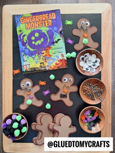 A Halloween-themed craft setup with a Gingerbread Monster book, gingerbread man cutouts, googly eyes, pom-poms, pipe cleaners, and plastic spider decorations—perfect inspiration for fall themed sensory bin ideas.