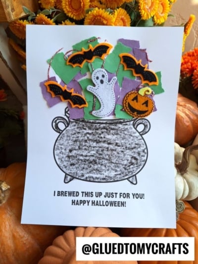 A Halloween craft shows a torn paper witch cauldron bursting with bats, a ghost, and a pumpkin made of colored paper. Text reads, I BREWED THIS UP JUST FOR YOU! HAPPY HALLOWEEN! Pumpkins and flowers frame the background.