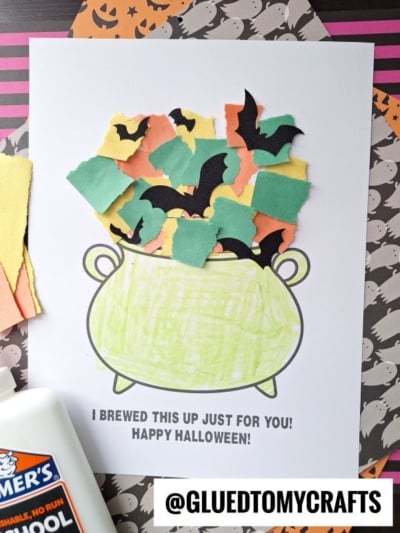 A Halloween craft featuring a torn paper witch cauldron outline filled with colorful scraps and bat shapes. Below, text says, I brewed this up just for you! Happy Halloween! Elmer’s glue and colored paper are nearby.
