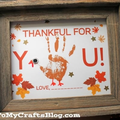 A framed craft printable features a handprint turkey and the phrase "Handprint thankful for you! LOVE, ______." Autumn leaves and stars decorate the border