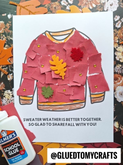 A fall craft shows a torn paper sweater coloring page covered in red paper pieces, felt leaves, and gold dots. Text says: Sweater weather is better together. So glad to share fall with you! Elmers glue is visible nearby.