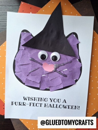A Halloween craft features a torn paper black cat with googly eyes, a pink nose, and a black witch hat on white paper. Text below reads “Wishing you a purr-fect Halloween!”.