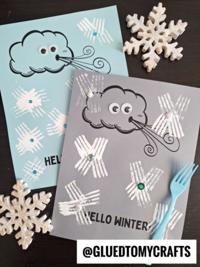 Two winter-themed craft papers with cartoon clouds blowing wind, googly eyes, and HELLO WINTER text. Fork painted snowflakes with sequins are stamped using white paint. Decorative snowflakes are nearby. @GLUEDTOMYCRAFTS text at bottom.