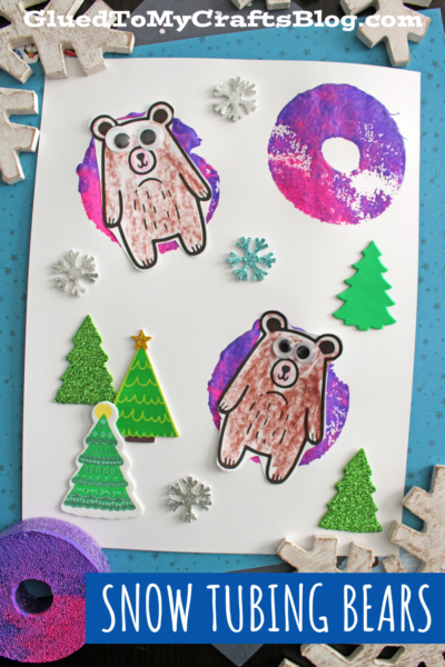 A winter-themed craft displays two paper bears appearing to snow tube on pool noodle stamped snow tube shapes, surrounded by paper trees and snowflake stickers on a white background. Text reads SNOW TUBING BEARS.