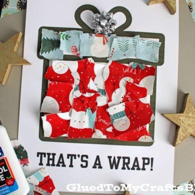 A holiday craft featuring a torn paper present made from patterned paper scraps, topped with a silver bow. Text reads THAT'S A WRAP! with gold star decorations around.