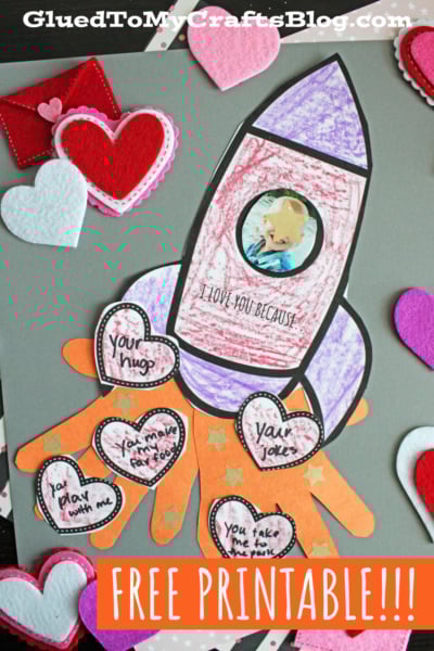 A colorful rocket craft made with hearts and felt, featuring a child's photo in the center.