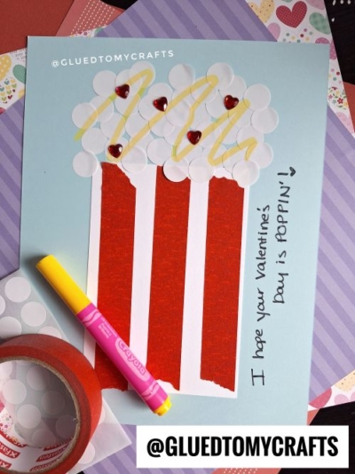A handmade Valentine’s Day card that’s perfect for POPCORN CRAFT IDEAS FOR KIDS—designed like a popcorn bucket with red and white stripes, yellow popcorn pieces, red heart stickers, and a sweet note: “I hope your Valentine’s Day is POPPIN’!”.