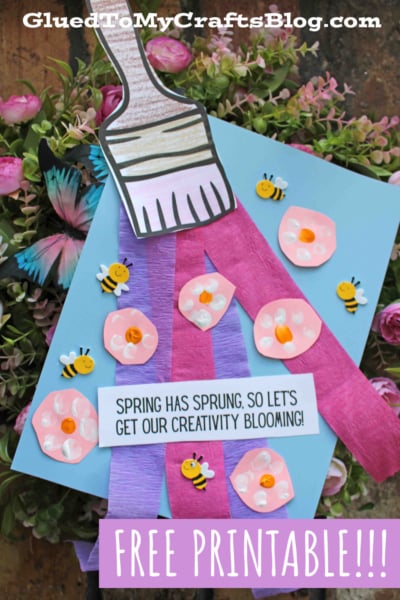 A colorful craft project featuring a paper paintbrush, purple and pink paper strips, flowers, and bees, with the text “Spring has sprung, so let’s get our creativity blooming!” and “Free Printable” at the bottom.