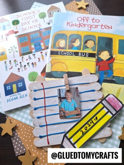 A back-to-school themed flat lay featuring two children’s books for back to school story time, a popsicle stick frame decorated as notebook paper with a child’s photo, star cutouts, and @GLUEDTOMYCRAFTS on the bottom.