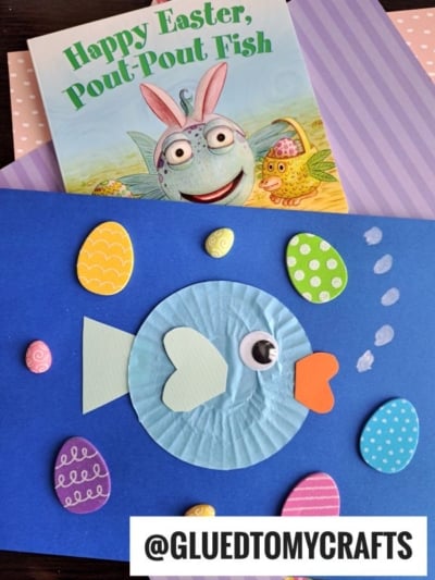 A children’s book titled “Happy Easter, Pout-Pout Fish” is shown with a blue fish paper craft made from a cupcake liner, paper cutouts, decorated Easter eggs, and fun cupcake liner card crafts. The handle @GLUEDTOMYCRAFTS is at the bottom.