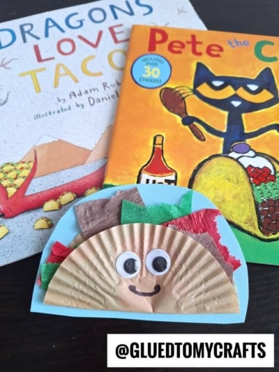 Two children’s books, Dragons Love Tacos and Pete the Cat, sit beside a paper taco craft with googly eyes and a smile—made from a coffee filter, colored paper, and tissue—plus inspiration for cupcake liner card crafts. The handle @GLUEDTOMYCRAFTS is visible.
