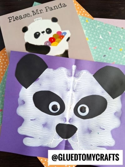 Children’s book Please, Mr. Panda and a symmetrical panda face craft made with white paint, paper cutouts, and googly eyes on purple paper, displayed on patterned sheets. @GLUEDTOMYCRAFTS is written at the bottom.