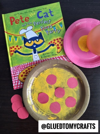 A childrens book titled Pete the Cat and the Perfect Pizza Party is next to a paper plate craft that looks like a pizza, yellow paint for cheese, red paper circles for pepperoni, and a balloon with yellow paint.