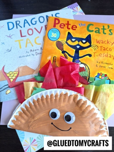 A paper plate taco craft with googly eyes sits in front of two childrens books: Dragons Love Tacos and Pete the Cat’s Wacky Taco Tuesday. Colorful tissue paper mimics taco fillings. @GLUEDTOMYCRAFTS is labeled at the bottom.