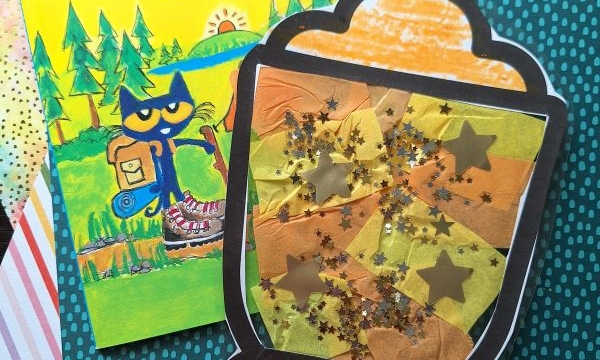 A Pete the Cat Goes Camping book lies next to a handmade lantern craft decorated with orange, yellow, and gold tissue paper, glitter, and star shapes. Both items rest on colorful, patterned paper backgrounds.