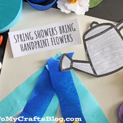 A craft scene with a glue bottle, blue and yellow felt flowers, blue crepe paper strips, a paper watering can, and a card reading “Spring Showers Bring Handprint Flowers,” features fun Spring Printables on a white background.