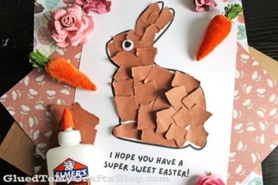 A paper craft of a bunny made from torn brown paper on white paper, with the message I hope you have a super sweet Easter! Nearby are fake flowers, carrots, a bottle of glue, and patterned paper.