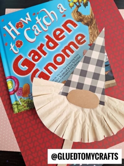 A children’s book titled How to Catch a Garden Gnome sits on patterned paper, next to a handmade paper gnome with a plaid hat and round nose. The handle @GLUETOMYCRAFTS appears at the bottom.