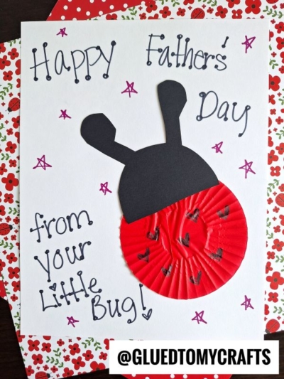 Homemade Father's Day cupcake liner card crafts—this sweet card reads "Happy Fathers Day from your little bug!" and features a ladybug made from a red cupcake liner, black paper, flower patterns, and purple doodles.