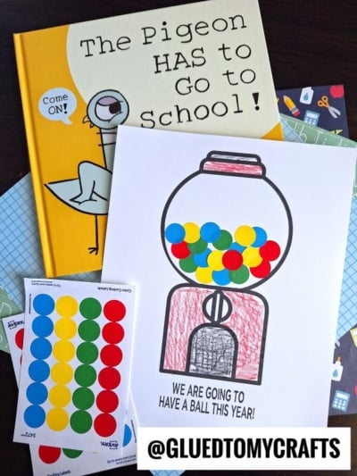 Flat lay of the book The Pigeon HAS to Go to School!, a gumball machine coloring page with colorful dot stickers—a fun gumball craft idea—and a pack of round colored labels; @GLUEDTOMYCRAFTS is at the bottom.
