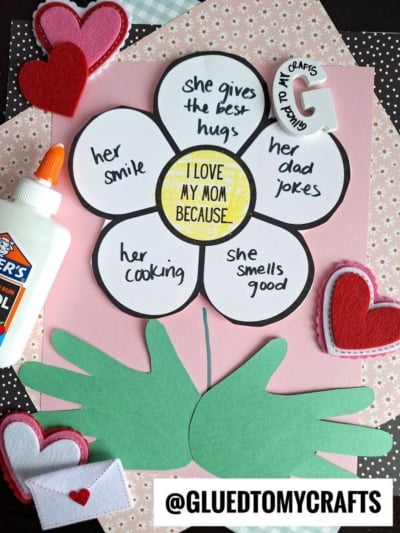 A paper flower craft makes adorable mother's day keepsakes, with a yellow center reading I LOVE MY MOM BECAUSE.... Each petal lists reasons like hugs, jokes, and smile. Green handprint leaves, felt hearts, glue, and a craft tag complete this heartfelt gift.