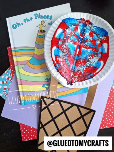 A colorful PAINT SPLAT CRAFTS project featuring the book Oh, the Places You’ll Go!, red, blue, and white paint splatters on a paper plate, colored paper sheets, and a brown paper ice cream cone. Text: @GLUEDTOMYCRAFTS.