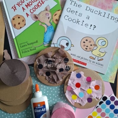 Two children’s books, “If You Give a Mouse a Cookie” and “The Duckling Gets a Cookie!?”, are displayed with craft supplies: colored paper, brown circles, cutouts, glue, tissue, and sticker dots. @GLUEDTOMYCRAFTS is labeled.
