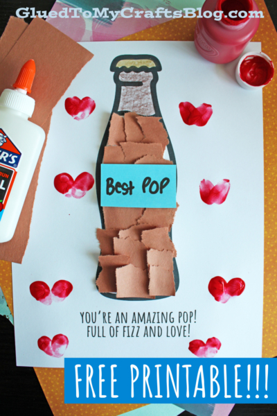 A craft project featuring a paper soda bottle decorated with brown paper squares, a blue label reading “Best Pop,” and red heart stamps. Text below says, Youre an amazing pop! Full of fizz and love! with “Free Printable!!!” banner.