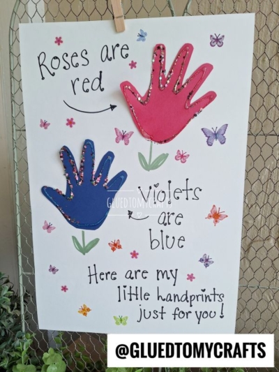 A handmade HANDPRINT FATHER'S DAY card features red and blue handprints, surrounded by butterflies and flower stickers. The text reads: Roses are red, violets are blue, here are my little handprints just for you! @GLUETOMYCRAFTS.
