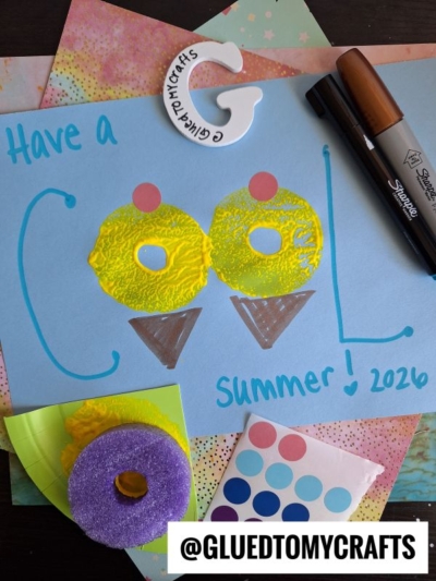 A colorful summer craft says “Have a COOL Summer! 2026” with “cool” spelled using yellow painted swim rings as Os. Markers, foam rings, and pool noodle stamped ice cream designs decorate the scene. @GLUEDTOMYCRAFTS is at the bottom.